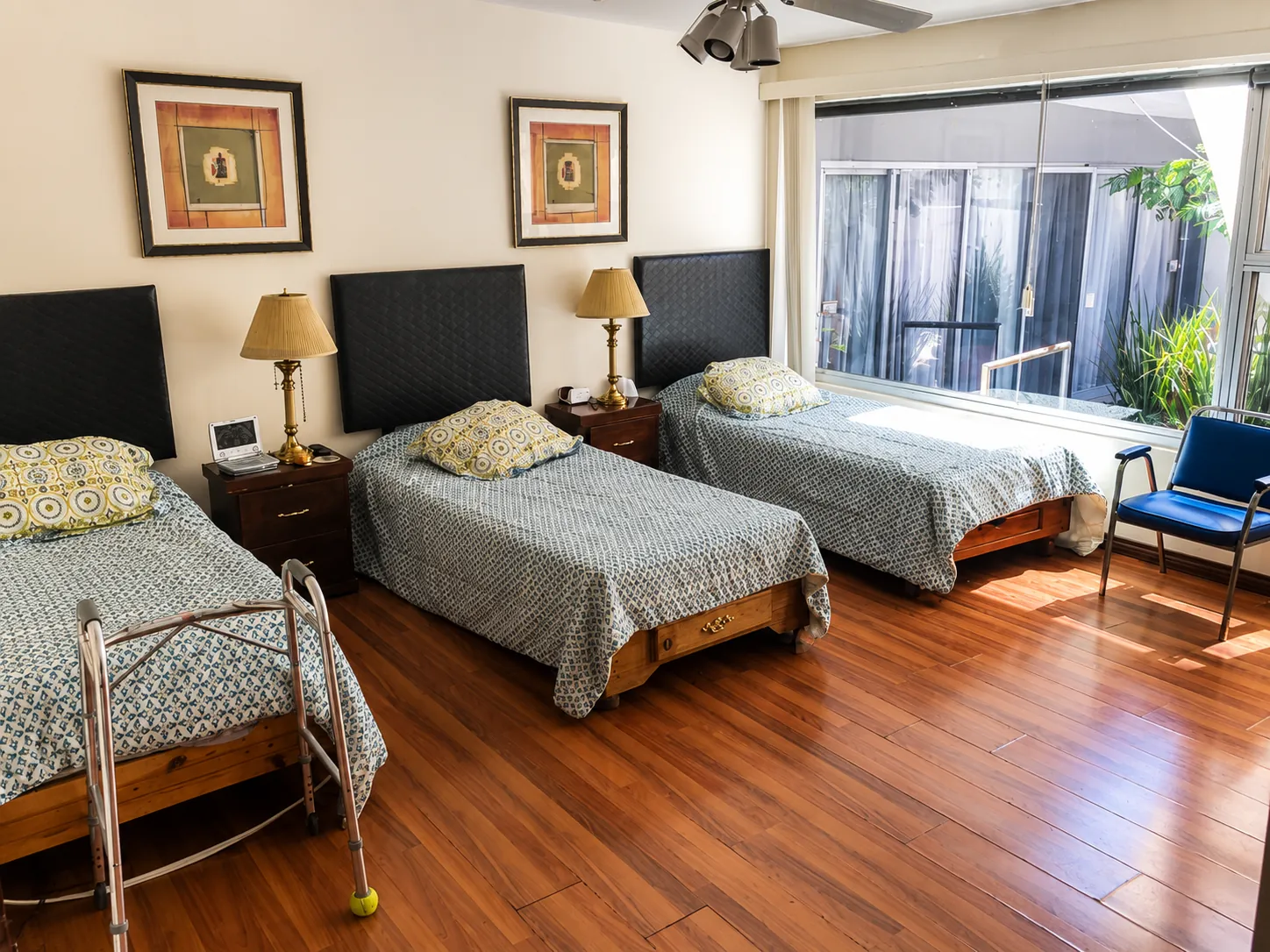 Habitación compartida de tres camas con andadera en residencia para adultos mayores en Chihuahua