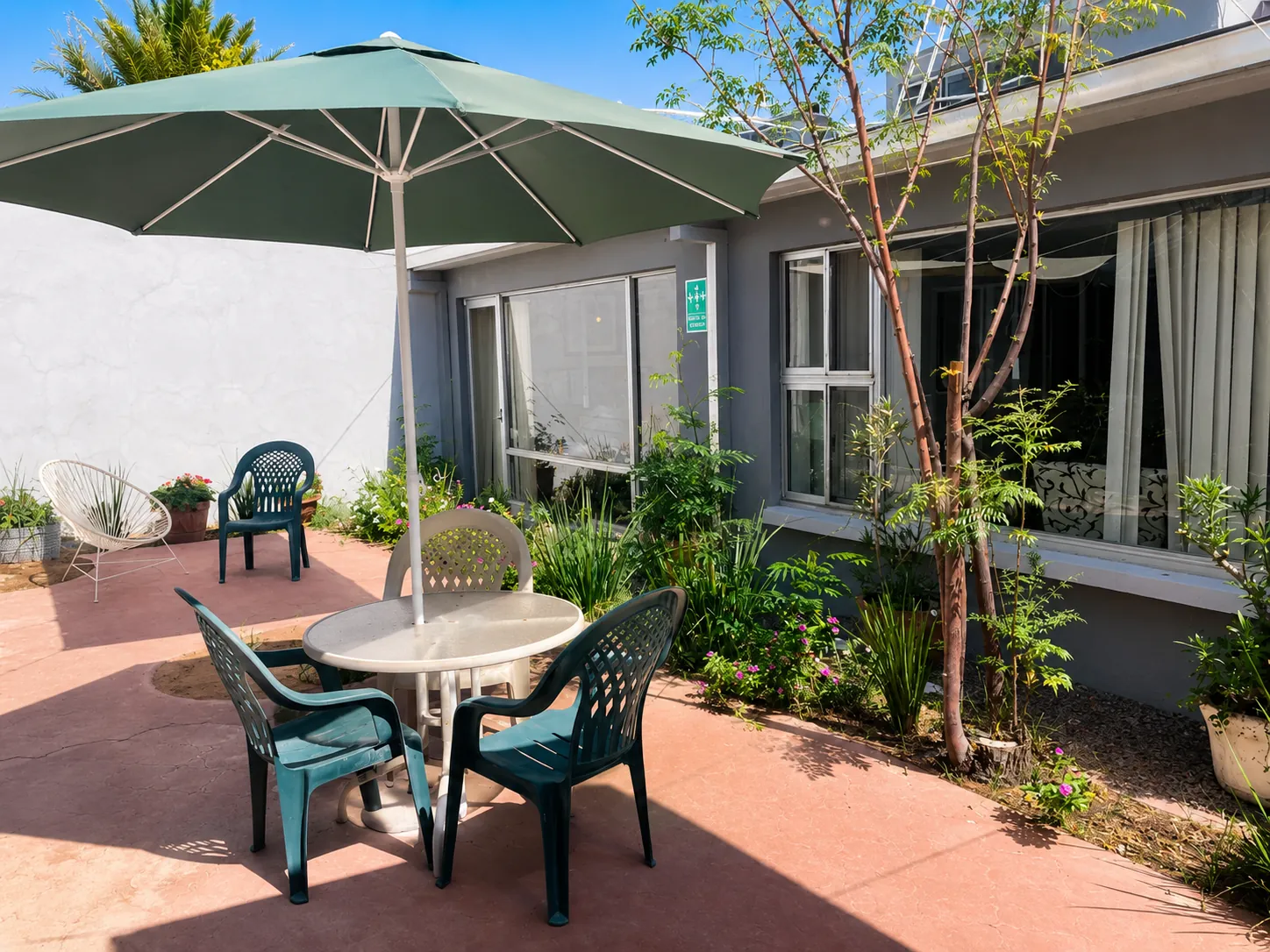 Terraza de convivencia con mobiliario y plantas en residencia para adultos mayores en Chihuahua